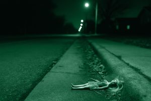 Bambola per terra su una strada buia di periferia, simbolo dell'omicidio di Athena Strand in Texas nel 2022.