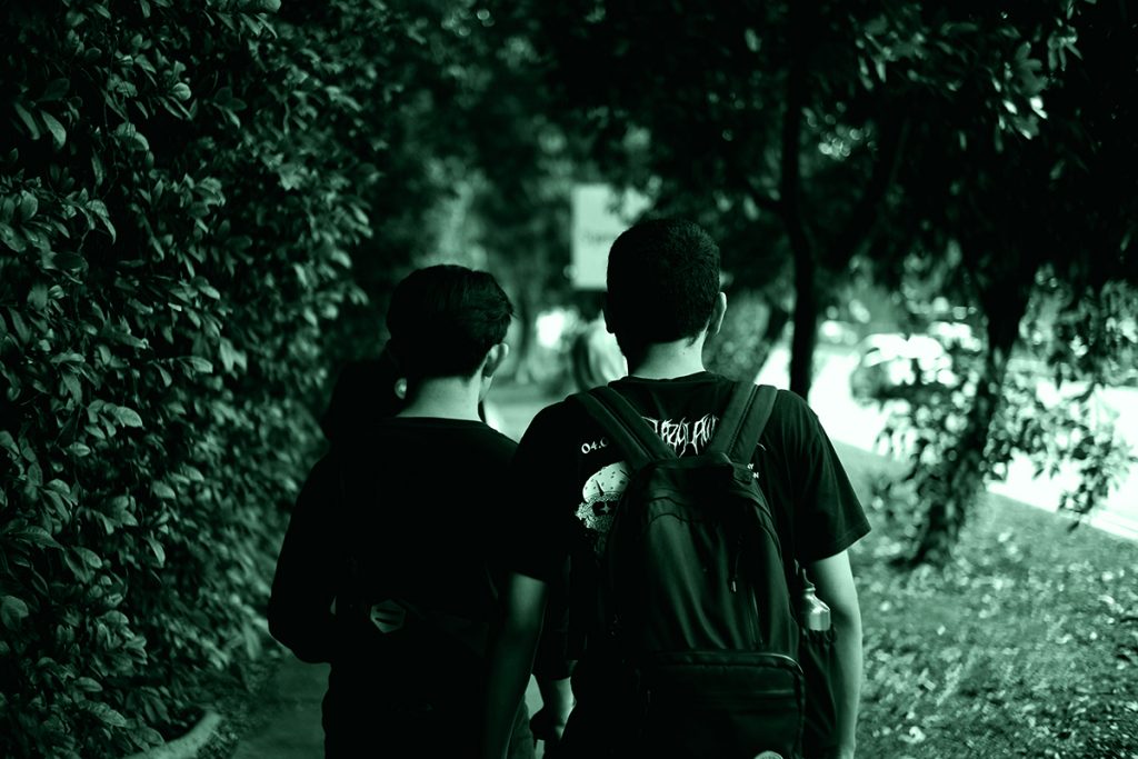 Due adolescenti che camminano di spalle, simbolo di crimini compiuti da adolescenti.