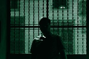 Uomo in prigione che simboleggia i disturbi di personalità più comuni tra criminali e serial killer.