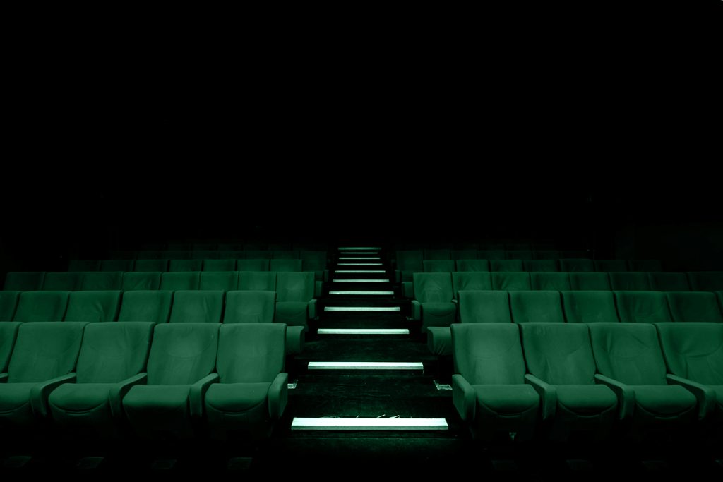 Sala cinematografica inquietante che richiama la messa in onda di film horror ispirati a crimini veri.