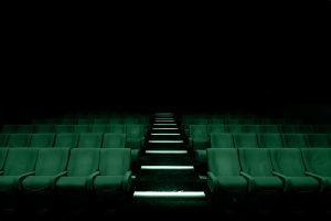 Sala cinematografica inquietante che richiama la messa in onda di film horror ispirati a crimini veri.