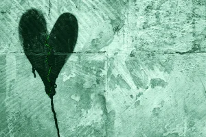 Un cuore spezzato disegnato su un muro, simbolo di un amore tossico, infelice, di love bombing e di frasi manipolatorie.