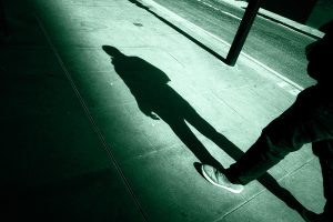 Figura che cammina da sola al buio, simbolo di un criminale spinto ad agire per un preciso movente.