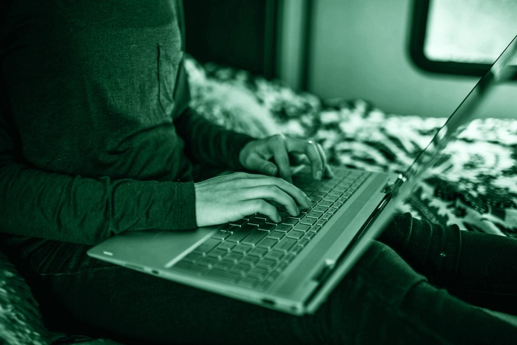 Persona che chatta al computer, simbolo di catfishing.