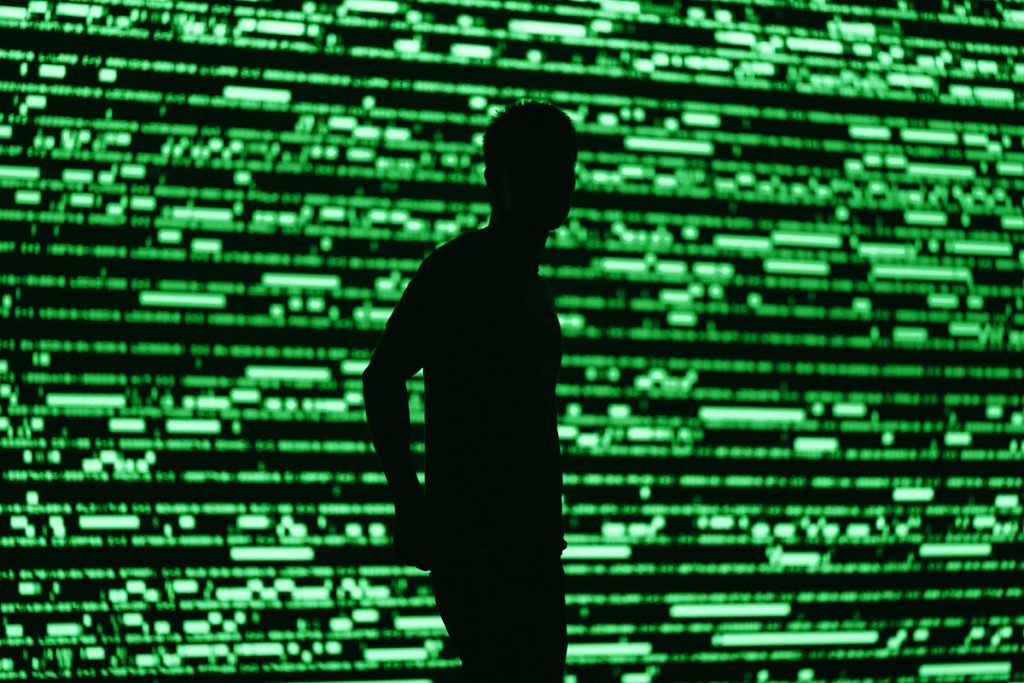 Silhouette di un uomo su sfondo che richiama un database astratto: immagine che richiama il database ViCAP dell'FBI