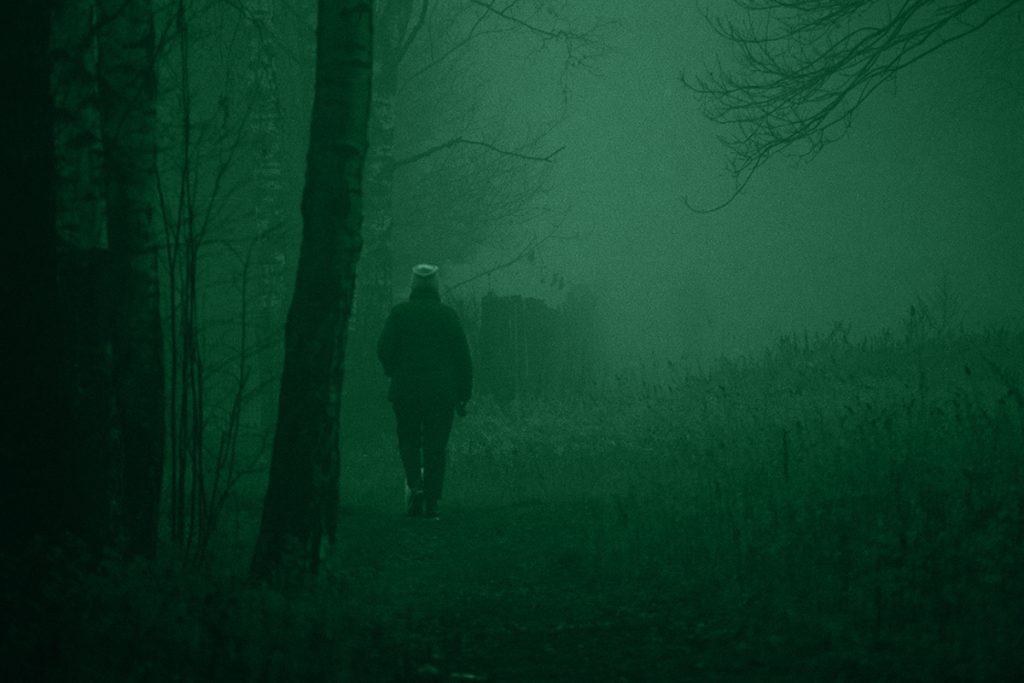 Figura di un uomo che cammina in una zona rurale isolata che simboleggia il Mostro di Firenze e le sue vittime.