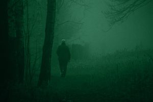 Figura di un uomo che cammina in una zona rurale isolata che simboleggia il Mostro di Firenze e le sue vittime.