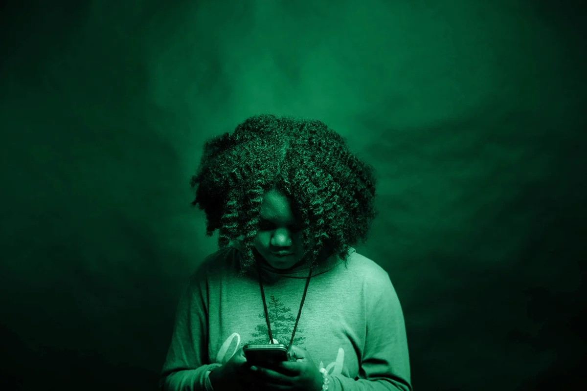 Bambina con un telefono cellulare in mano, simbolo dei casi reali di cyberbullismo che hanno colpito minori.