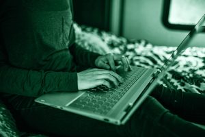 Persona che chatta al computer, simbolo di catfishing.