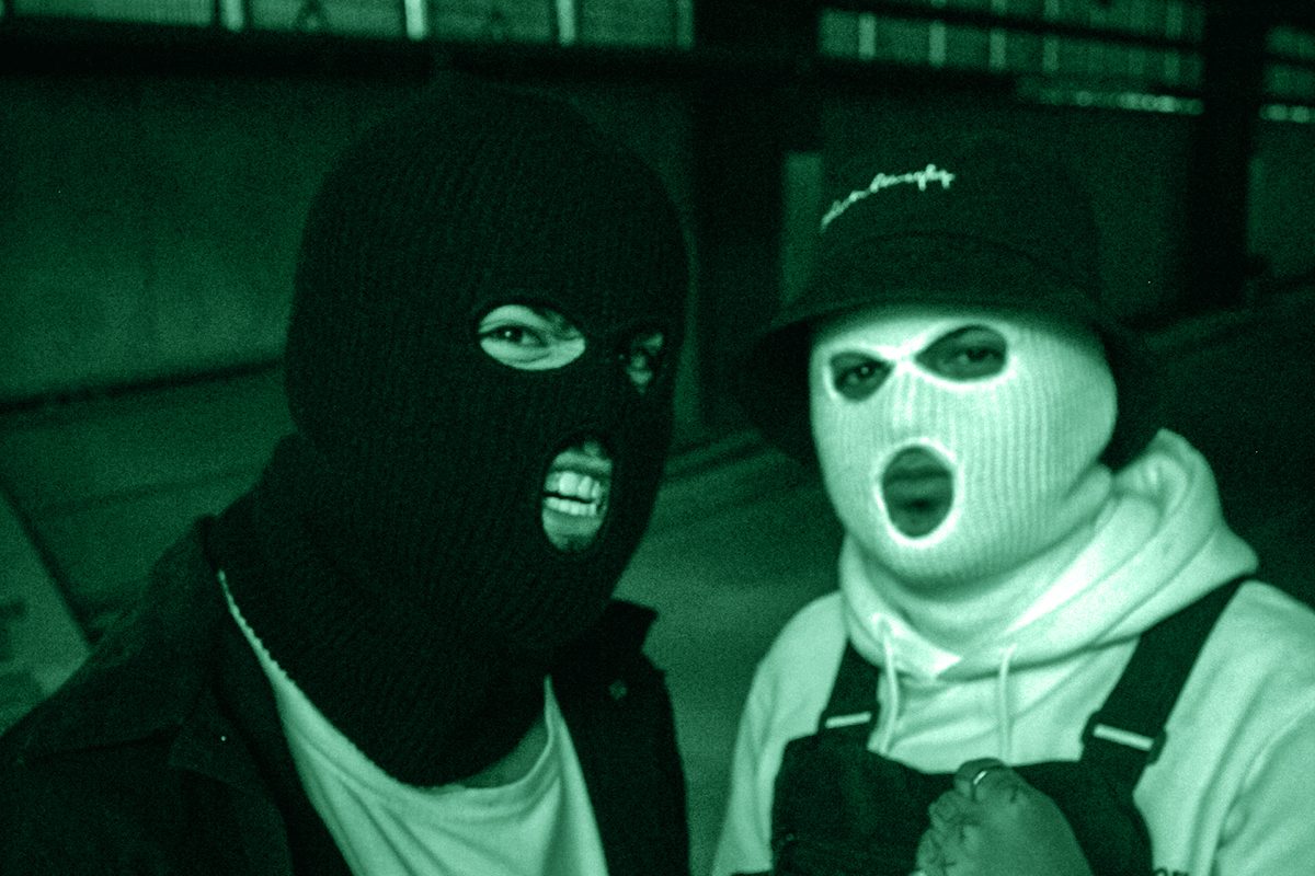 Due uomini con passamontagna che fanno una smorfia guardando nell'obiettivo della fotocamera: simbolo dei criminali più stupidi e maldestri mai esistiti.