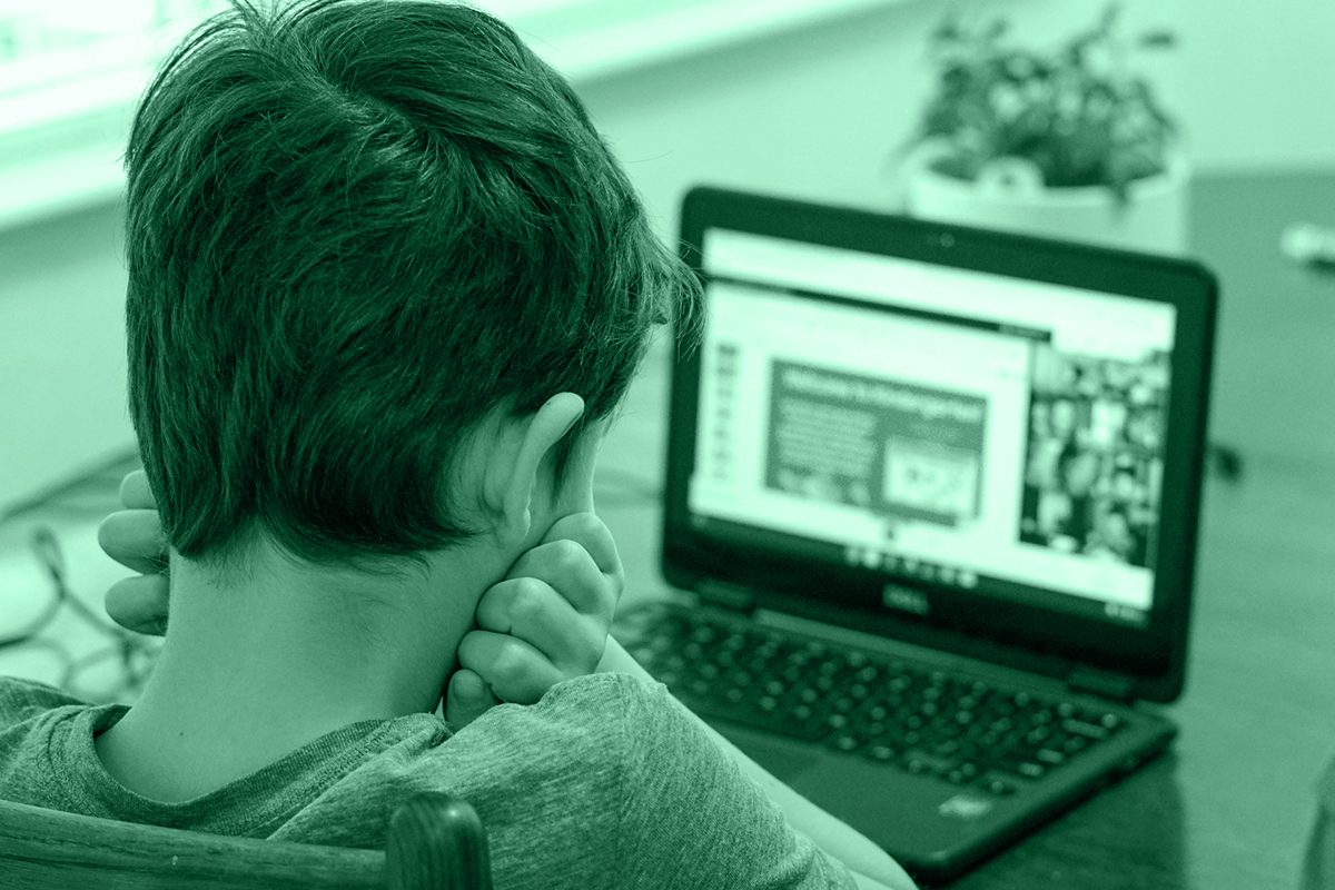 Bambino davanti a un computer, simbolo del fenomeno del cyberbullismo