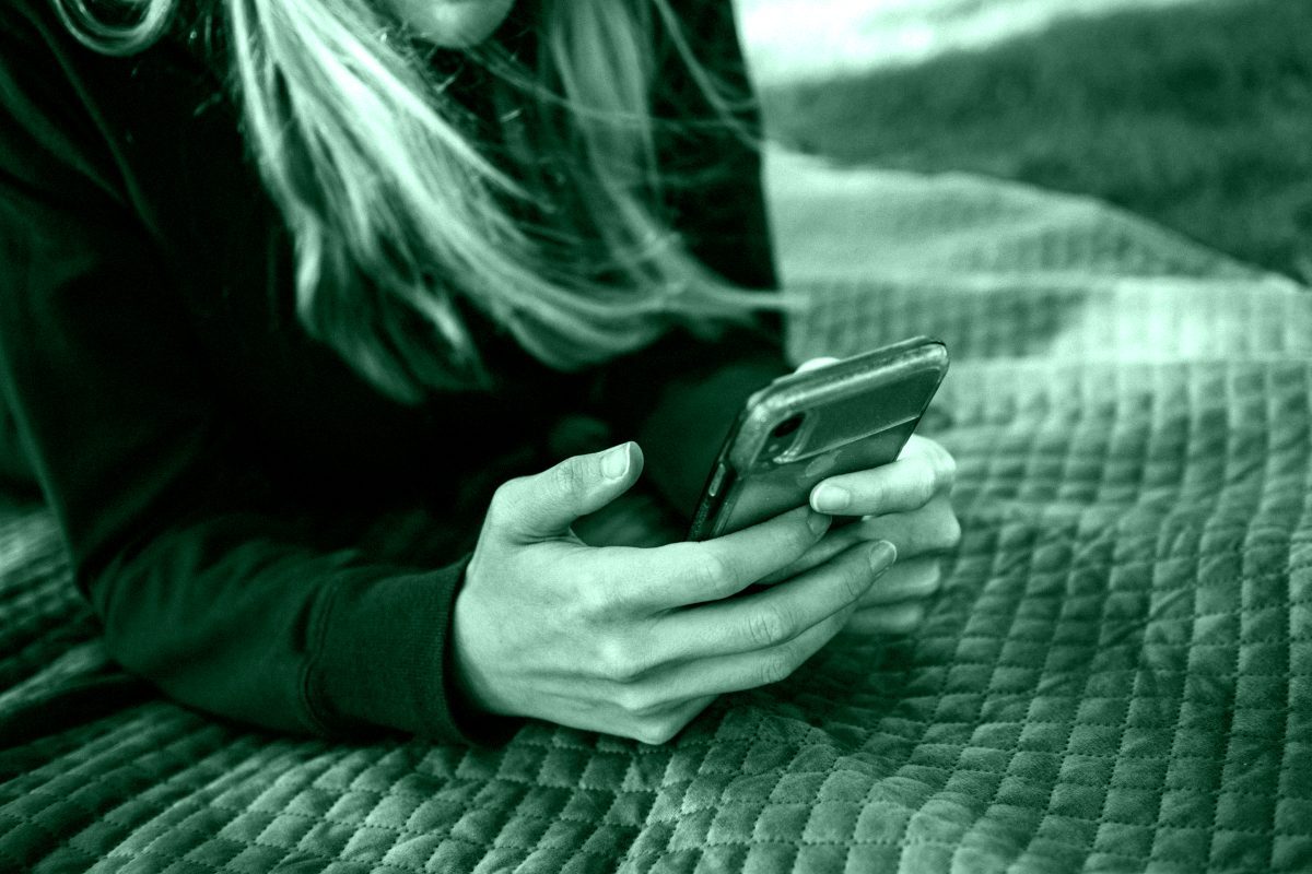 Donna sola osserva il cellulare, simbolo del silenzio del ghosting