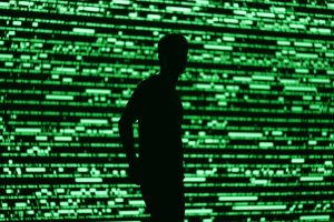 Silhouette di un uomo su sfondo che richiama un database astratto: immagine che richiama il database ViCAP dell'FBI